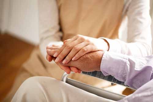 A Conservator holds an elderly person 's hand